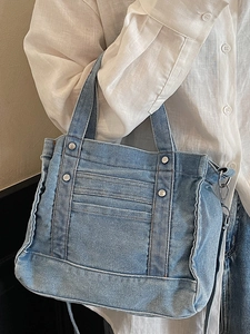 Light blue denim tote bag with silver studs and frayed edges for summer casual styling
