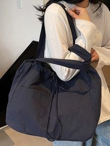 Large waterproof nylon tote bag with drawstring closure and shoulder straps for travel