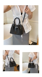 Detailed close-up of a black bucket bag with vertical knit texture and metal buckle strap