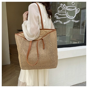 Detail of woven straw tote bag with brown leather shoulder strap in a cafe setting