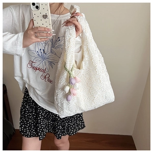 Détail du sac cabas en dentelle florale blanche avec breloques tulipes au crochet et maille