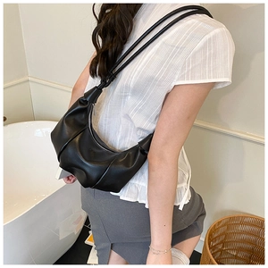 Detail of a black crescent shoulder bag featuring premium leather texture and slouchy folds