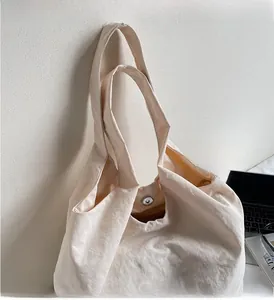 Détail du cabas en toile blanc cassé avec broderie Chase et fermeture magnétique