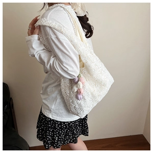 Détail d'un sac à bandoulière en dentelle blanche avec texture florale ajourée complexe
