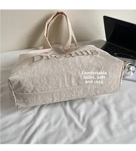 Détail de la broderie Dreams sur un grand sac cabas blanc cassé pour un look moderne
