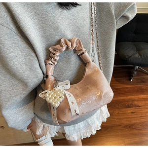 Détail de la poignée plissée avec pendentif cœur perlé et nœud en dentelle