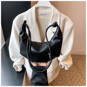 Detail of black matte leather dumpling bag with stylish knot strap and zipper