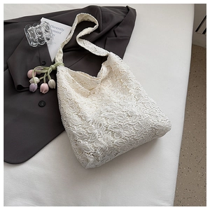 Détail d'un sac cabas en dentelle florale blanche avec breloques tulipes colorées