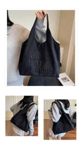 Détail du sac cabas noir avec inscription Chase My Dreams en relief et grande capacité