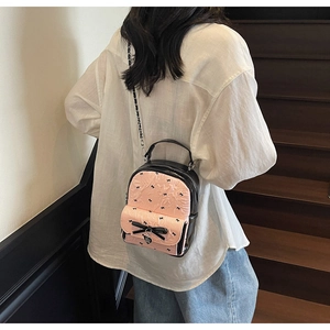 Close-up of pink and black seersucker backpack with bow pattern and metal chain strap
