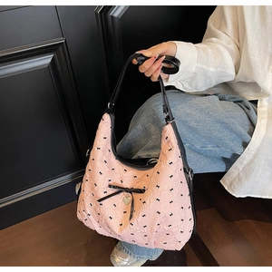 Dettaglio della borsa hobo rosa a pieghe con stampa di fiocchi e ciondolo a cuore