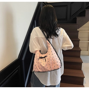 Dettaglio della borsa a spalla rosa con fiocco nero e motivo a cuore testurizzato