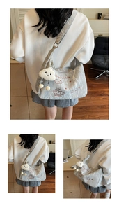 Detail of silver-grey pleated fabric shoulder bag with cute cloud charm and cat embroidery
