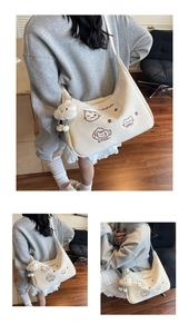 Detail view of cream crescent crossbody bag featuring cute cat embroidery and cloud pendant