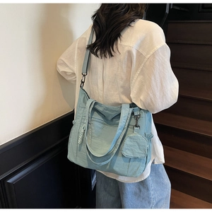 Detail of light blue canvas tote bag with adjustable strap and small round coin purse