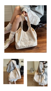 Détail du sac cabas en toile blanc cassé avec texte en relief 3D Chase My Dreams gravé