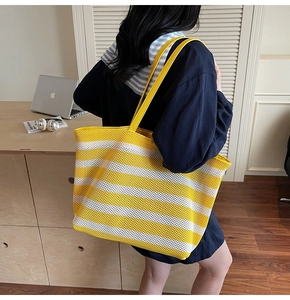 Macro shot of yellow and white striped woven tote bag texture with mesh design