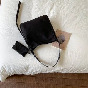 Set borsa tote minimalista in tela nera con pochette su lenzuola bianche