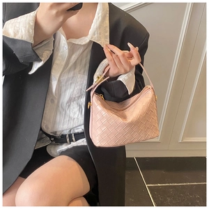 Detail of pink woven leather hobo bag with gold zipper held by model in black blazer