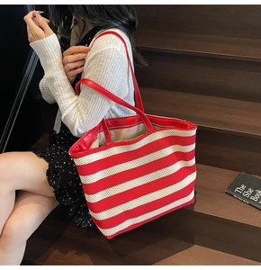 Detail of red and white striped tote bag with leather straps on wooden stairs
