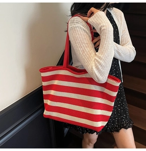 Close-up of red and beige striped mesh tote bag with fine shoulder straps on stairs