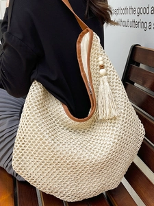 French straw woven tote bag with brown leather trim and tassel for beach vacations