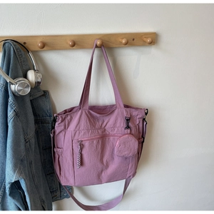Pink nylon tote bag details with front zipper pocket and round coin purse hanging on hook