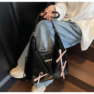 Dettaglio della borsa Hobo nera con fiocchi rosa e borchie argentate a cuore