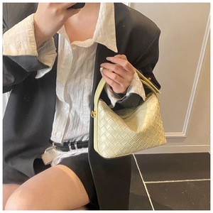 Detailed close-up of light green woven leather hobo bag with gold metal hardware details