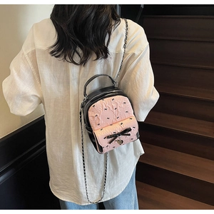 Girl's sweet bow seersucker small backpack shown on model back on wooden stairs