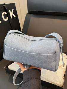 Fashionable light blue pillow shaped crossbody bag with textured leather and adjustable strap