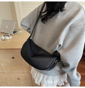 Vue détaillée d'un sac à main noir pour femme en cuir avec une texture litchi