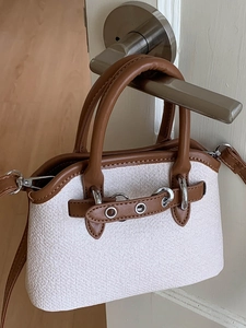 Minimalist white woven shell bag with brown leather trim and metal hardware details