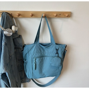 Detail view of mist blue canvas tote with adjustable strap and small round coin purse