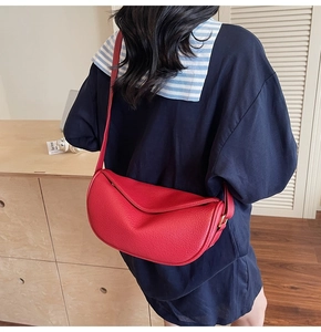 Détail du sac bandoulière demi-lune en cuir grainé rouge avec boucle dorée réglable