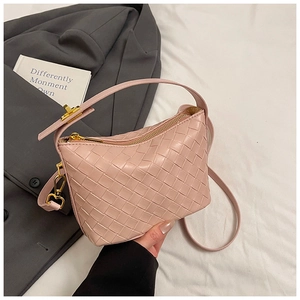 Close-up of pink woven leather handbag detailing golden zippers and metallic hooks