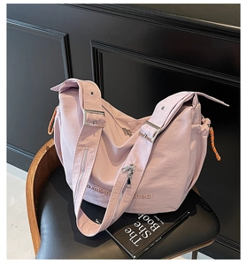 Detail of lavender casual crossbody bag with wide shoulder strap and side drawstring pocket