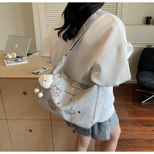 Detail of grey pleated Hobo bag with cute cat embroidery and cloud plush charm