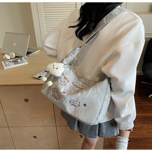 Detail showing wrinkled silver fabric texture and cute cat embroidery on shoulder bag