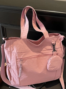 Pink nylon tote bag with multiple pockets and adjustable shoulder strap for daily use