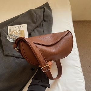 Détail du sac en cuir grainé marron foncé avec boucle en métal doré poli brillant
