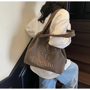 Détail de la broderie Chase My Dreams sur un sac cabas décontracté marron foncé