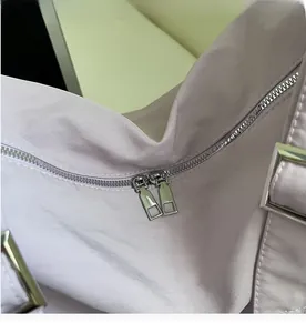 Detail of smooth double metal zippers on a purple canvas commuter crossbody bag