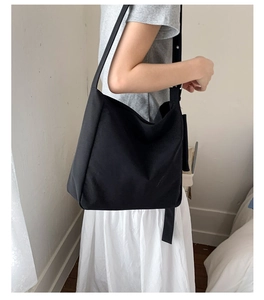 Side view of a black minimalist hobo bag worn by a model for a stylish daily commute look
