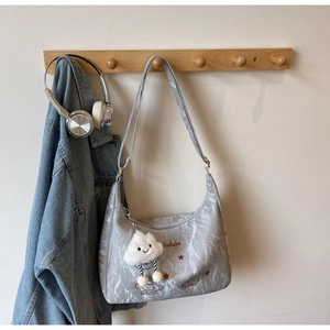 Detail of light gray crossbody bag featuring cute star embroidery and plush cloud charm