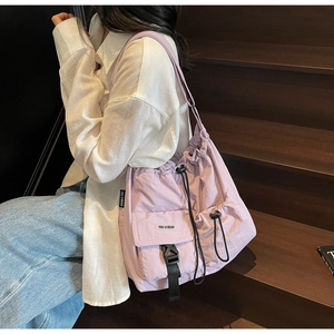 Detail of lavender nylon tote with drawstring closure and front buckle pocket for women