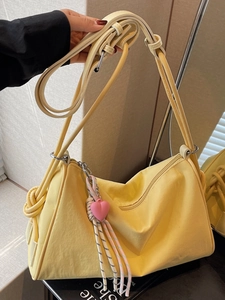 Minimalist yellow canvas pillow bag with knotted strap and pink heart charm