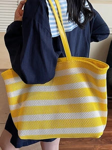Large yellow and white striped woven tote bag with leather straps for summer beach use