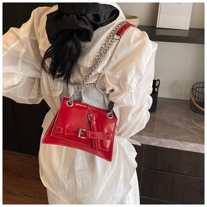 Vue mannequin d'un sac bandoulière rouge brillant avec chaîne argentée et boucles
