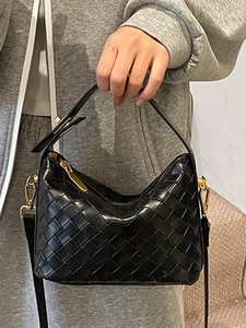 Fashionable black woven handbag with gold hardware and detachable shoulder strap